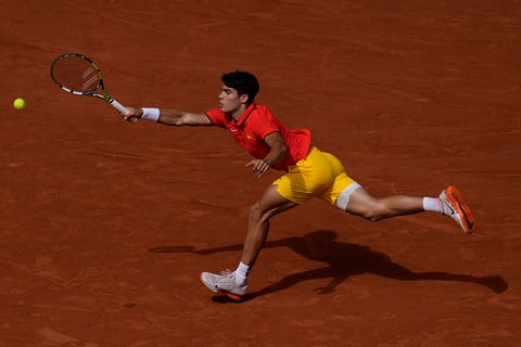 Carlos Alcaraz runs to return the ball to Novak Djokovic